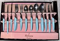 Full flatware set in original box, showing knives, forks, spoons with turquoise Bakelite handles and polished stainless steel heads