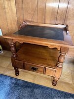 Front angle view of the wooden side table showing the slate top, bottom shelf and the drawer with metal handle.