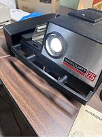 Close-up image showing Airequipt 125 projector front with lens, power light on and clear branding.