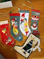 Full view of five vintage felt Christmas stockings laid out, showing varied holiday designs and colors