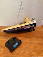 Front side view of Nikko Seahawk RC Boat with remote control showing the side logo and antenna.