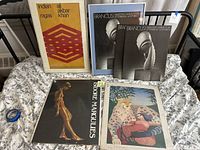 Framed Indian Ragas print with geometric red and orange design, two Brancusi art books, and two other art books on fabric background