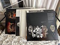 Five large art books laid horizontally with covers facing up, focusing on African masks and sculptures, showing wear on edges.