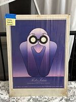Full view of the framed poster artwork showing a cartoon figure in purple tones with glasses.