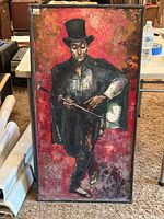 Full view of the framed painting showing a man in black attire with top hat against a red background, with visible water damage.