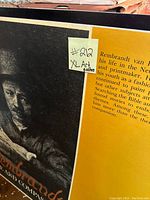 Close-up of Rembrandt poster with yellow background and informational text, showing art poster sticker #212 XL Art