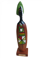 Front view of the carved wooden figurine showing the detailed painted geometric shapes and black and white face.