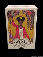 Box showing cover image of a confident black woman in a red jacket holding a wand, surrounded by flowers and mystical symbols, with the title 'Modern Witch Tarot Deck by Lisa Sterle'