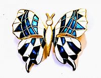 Front view of vintage enamel butterfly brooch showing detailed wing enamel work in blue, white, black, and gold-tone metal outline.