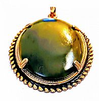 Round jade pendant with polished green jade set in a gold-tone rope border frame with prong settings and bail attachment.