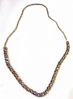 Full view of the vintage rhinestone and lucite necklace showing the rhinestones and lucite beads along the gold-tone chain.