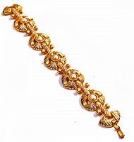 Full view of vintage gold-tone rhinestone bracelet showing floral and fan-shaped links with pearl-like centers.