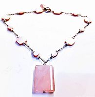 Image of the full necklace showing the rectangular rose quartz pendant and the beaded chain with pink rose quartz stones.