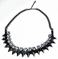 Front view of vintage spike necklace showing black spikes and clear rhinestones on dark chain against white background.