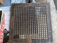 Top view of antique cast iron register showing square grid pattern and overall condition