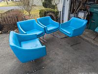 Four blue vinyl armchairs arranged outside, showing the seating and condition with rips in vinyl upholstery.