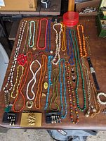 Full overview of all jewelry items and red tin container arranged on table