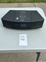 Front view of the black Bose Wave Radio showing buttons, display, and front speaker grille.