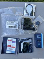 Complete kit contents laid out showing board, case, adapters, header, and documentation.