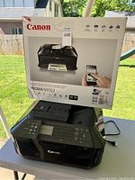 Canon PIXMA MX922 printer front and box showing model and wireless features.