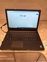 Dell Inspiron 1515 laptop open powered on showing Google homepage on screen and keyboard