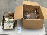 Top-down view of open cardboard boxes holding a large quantity of postcards and album pages.