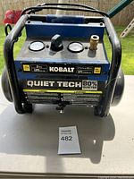 Front view of blue and black Kobalt air compressor with two pressure gauges and control knob visible.