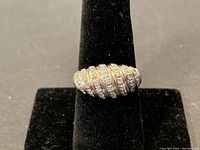 Front view of ring on black display cone showing domed design and diamond channels