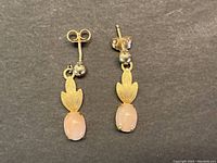 Front view of both earrings on black background