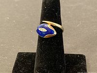 Front view of blue enamel snake ring on display stand