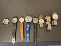 Eight watches lined up on black background showing full set and strap varieties