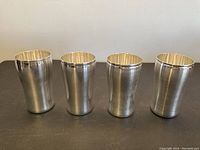 Front view of all four silver beakers in a row