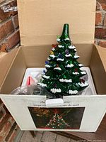 Ceramic Christmas tree in original cardboard box with Styrofoam packaging and electrical components visible.