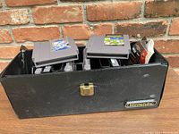 Photo of black Nintendo branded game case with multiple NES cartridges arranged inside, some partially lifted.