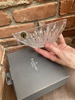 Waterford Crystal square bowl held over its original black box with Waterford Crystal logo visible. The bowl has a green Waterford sticker and cuts along the sides.
