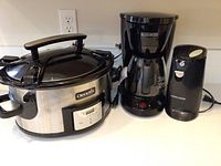 Photo showing all three kitchen appliances: the Crock Pot slow cooker, Black & Decker coffee maker, and can opener, placed on kitchen counter.