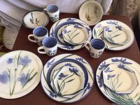 Photo of entire dish set showing plates, octagonal salad plates, mugs, and bowls with blue floral decoration by Steinman.