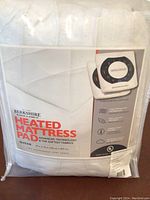 Front view of packaged Berkshire heated mattress pad showing product name and main features with queen size noted.