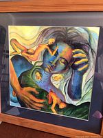 Pastel wall art framed in a wood frame with abstract nude figures in blue and earth tones