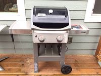 Front view of closed grill showing lid with integrated thermometer and two burners