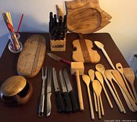 Full view of the kitchen cutlery block, wooden cutting boards, spoons, knives, and other utensils.