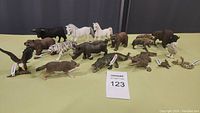17 Schleich animal figures arranged on table including horse, tiger, bear, hyena, eagle, boar, crocodiles, and wolf.