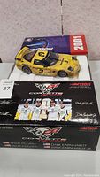 Front view of the 2001 Corvette Racing diecast model in packaging showing yellow car with black hood and racing decals, part of the limited edition lot.