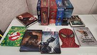 Photo showing multiple DVD and box set covers including Ghostbusters, Batman, Spider-Man, Pirates of the Caribbean, Harry Potter, Indiana Jones, and Back to the Future.