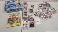 Two sealed O-Pee-Chee 1991-92 hockey card boxes and various loose hockey cards displayed on a white surface