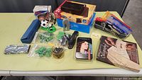 Overview of the table displaying an assortment of office supplies including a stapler, tape dispenser, scissors, correction fluid, paper clips, and small boxes.