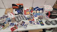Wide view of assorted sports collectibles including foam fingers, baseballs, trading cards, football, display cases, promotional canisters, and memorabilia