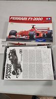Open box with Ferrari F1-2000 parts and instruction manual visible inside