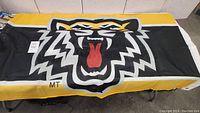 Large Tiger Cats flag showing roaring tiger face design in black, white, yellow, and red on black background with yellow and white border