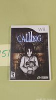 Front view of the Wii game 'Calling' showing the cover art of a girl holding a teddy bear with the title and ESRB rating.